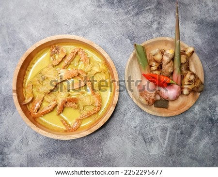 Crab Coconut Milk Soup or Kepiting Kuah Santan or Crab curry. Crab curry in wooden bowl isolated on white background. Indonesian food. Royalty-Free Stock Photo #2252295677