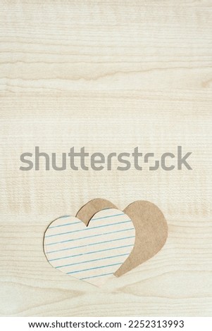 Craft paper hearts on wooden background. Hopeless romantic aesthetic, Flatlay, top view vertical banner. Template on Valentines day.