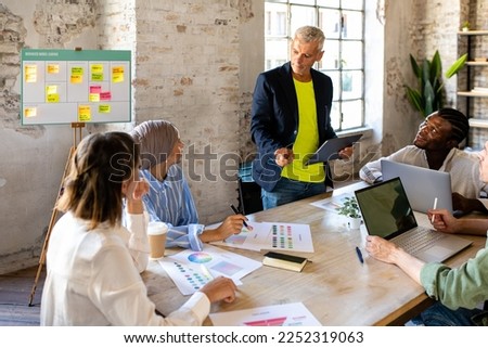 Group of business people working and taking instructions from the mature man standing, portrait of successful creative business teamwork, diverse and multicultural colleagues of fashion or designer  Royalty-Free Stock Photo #2252319063