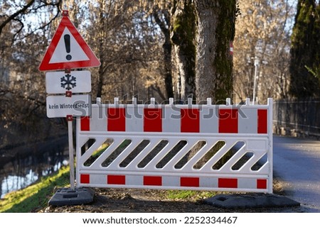 A warning sign with snowflakes and a fence in Austria. "Kein Winterdienst" from German means a lack of winter road clearance.