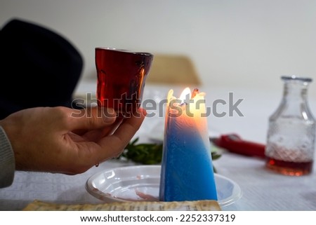 When the Shabbat ends, it is a Jewish custom to light a candle, smell fragrant plants and say a blessing on wine. on a jewish siddur written inside it "Havdlah Royalty-Free Stock Photo #2252337319