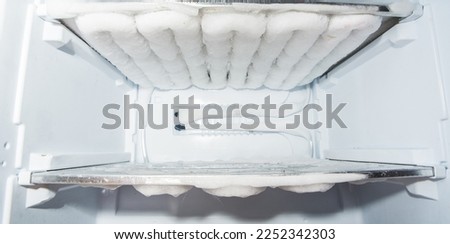 Defrost Freezer.  container covered with melting ice, water in the refrigerator.