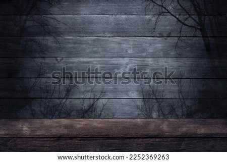 Halloween, wooden gray background. An old wooden table and the shadows of dead trees and bats at night with a place to place the product.