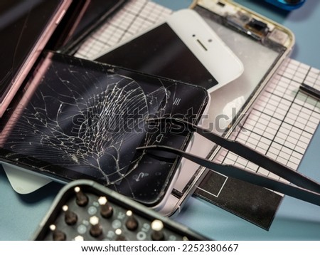Old broken smartphone and repair tool. The concept of computer equipment, mobile phones, electronics, repair, modernization and technology. Close-up.