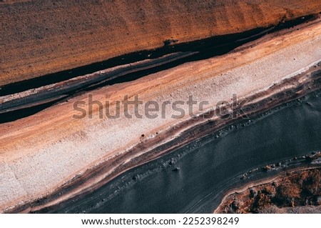 Explore the geological history of the earth with this photo of volcanic ash layers. The different hues of ash and rock tell a story of past eruptions, while offering a glimpse into the terraformation  Royalty-Free Stock Photo #2252398249
