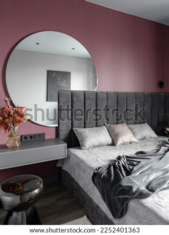 Viva magenta color in the interior. Bedroom . Round mirror. Bedside table . Bright bedroom. Pantone .