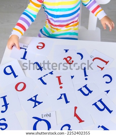 The child learns English letters. Selective focus. Kid.