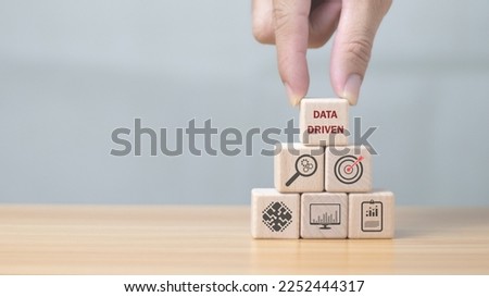Data-driven marketing ideas Big data collection and analytics Personalized and contextual marketing hand holding a wooden cube Royalty-Free Stock Photo #2252444317
