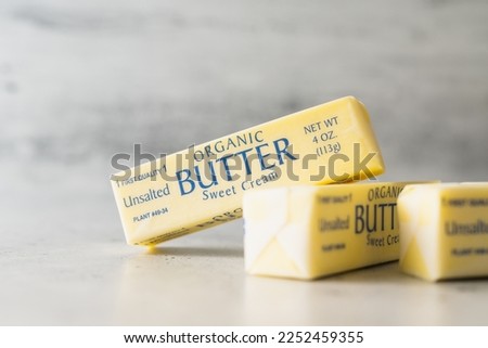 Butter sticks close-up. Wrapped organic unsalted butter sticks on a light grey background, copy space Royalty-Free Stock Photo #2252459355