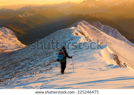 A man in beautiful  mountain sunset winter landscape  snow background, adventure hobby extreme tracking
