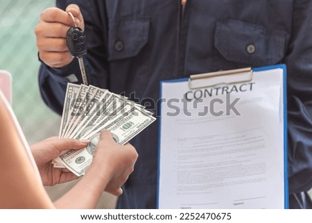 car salesman is making deal contract with lender. Used cars cheaper than new cars. buy used car must be thoroughly examined. Before lender signing contract deal leasing.