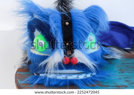 close up image of blue lion dance head costume on the table
