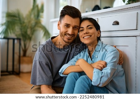 Happy couple enjoying in their time together at home and looking at camera. Royalty-Free Stock Photo #2252480981