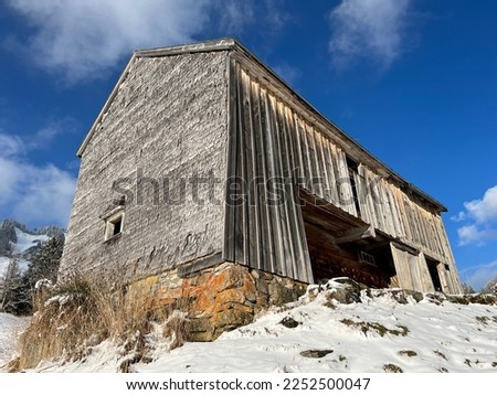 Indigenous alpine huts and wooden cattle stables in the Swiss Alps covered with fresh first snow over the Lake Walen or Lake Walenstadt (Walensee), Amden - Canton of St. Gallen, Switzerland (Schweiz)