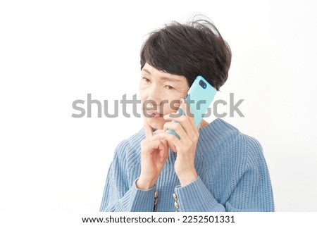 Asian senior woman calling with the smartphone in white background