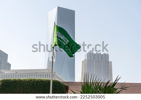 flag of Saudi Arabia against the background of a tall building,