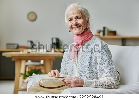 Senior woman embroidering during her leisure time Royalty-Free Stock Photo #2252528461