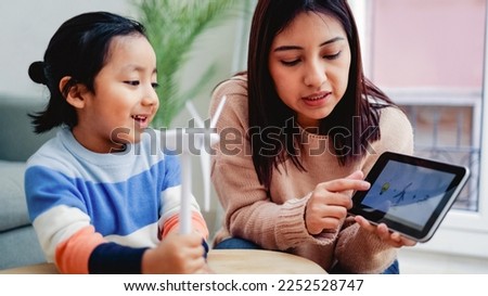 Asian kid learning about sustainable energy at home school class - Focus on teacher mother face Royalty-Free Stock Photo #2252528747