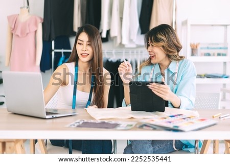 People tailor working in fashion design concept. Happy smile two young adult asian woman designer talking together. Workshop studio background.