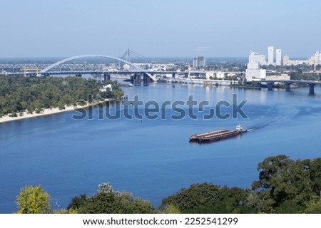 Kiev city bridge over the Dnieper river. Scenic view of the city landscape. barge on the water, ship floating on the river. The famous bridge. Residential buildings. view to the big river, blue water