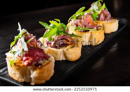 bruschetta with roast beef and cheese on plate Royalty-Free Stock Photo #2252550971