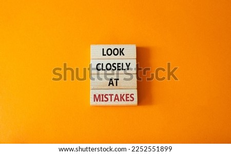 Look closely at mistakes symbol. Wooden blocks with words Look closely at mistakes. Beautiful orange background. Business and Look closely at mistakes concept. Copy space.