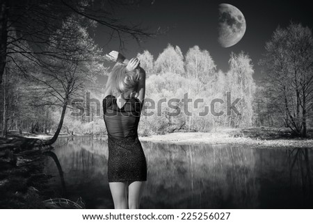 the moon rises over the lake in a serene hour