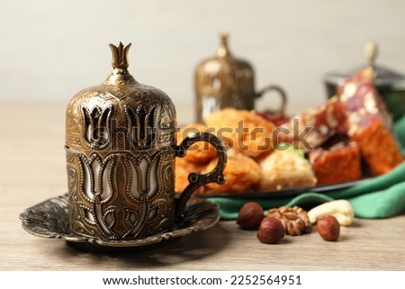 Tea, baklava dessert, nuts and Turkish delight served in vintage tea set on wooden table. Space for text