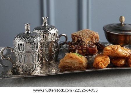 Tea, baklava dessert and Turkish delight served in vintage tea set on grey textured table, closeup