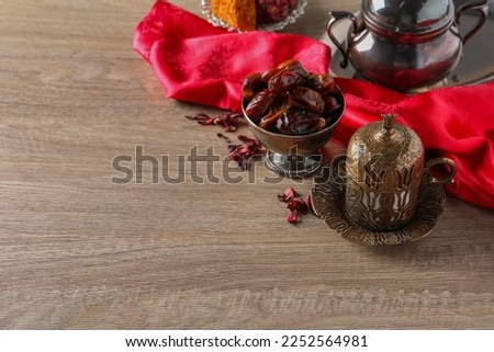 Tea and date fruits served in vintage tea set on wooden table, space for text
