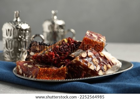 Tea and Turkish delight served in vintage tea set on grey table, closeup