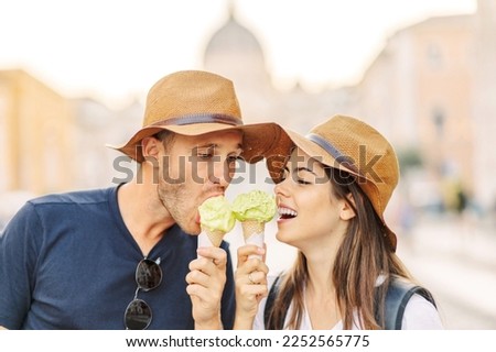 Happy couple eating ice cream in Rome, Italy. Beautiful bright ice cream with different flavors in the hands of a couple. A picture of a happy couple showing ice-cream cones. Valentine's Day