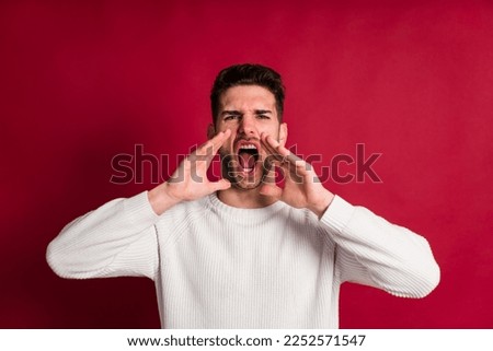 Excited man screaming on red background