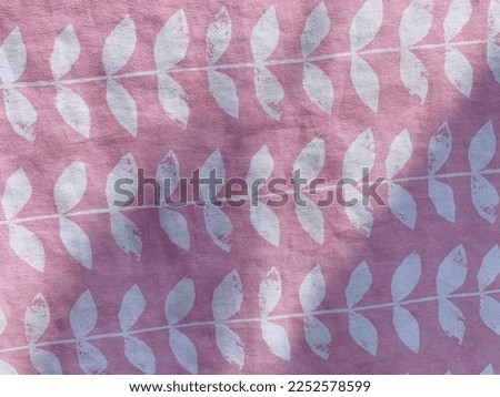 Purple fabric background with a white leaf pattern