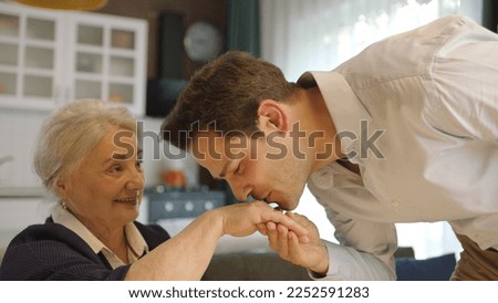 Young man kissing his old mother's hands during the feast (Ramadan or Şeker Bayram). People who follow Muslim traditions.A man kissing his mother's hands, celebrating Eid or Mother's Day.Kissing Hand. Royalty-Free Stock Photo #2252591283