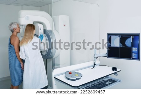 Mammogram procedure in medical clinic, mammography. Female mammologist positions mature woman at imaging machine to receive mammogram Royalty-Free Stock Photo #2252609457