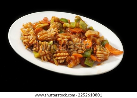 Squid (calamari ) sweet and sour souce, Is a popular Arabic-Chinese delicacy all over Arabs. Battered sea food, Chinese cuisine pictures, isolated on Black background.