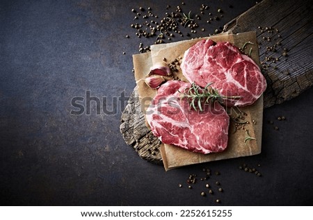 Raw pork neck with spices and herbs for grilled steaks Royalty-Free Stock Photo #2252615255