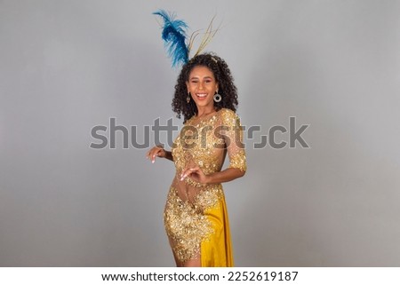 Brazilian afro woman posing in samba costume over yellow background with free space 