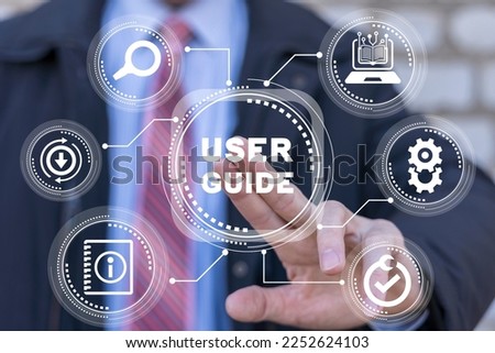 Businessman using virtual touchscreen presses the inscription: USER GUIDE. Download user manual book. Royalty-Free Stock Photo #2252624103
