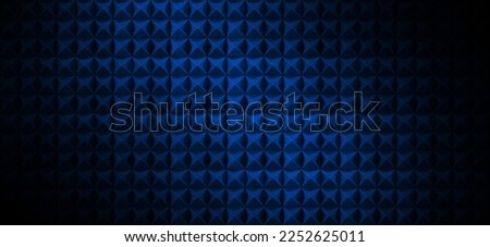 Dark acoustic foam wall with blue light. Recording studio room background with sound proofing texture. Radio broadcast or podcast background with copy space for website banner design Royalty-Free Stock Photo #2252625011