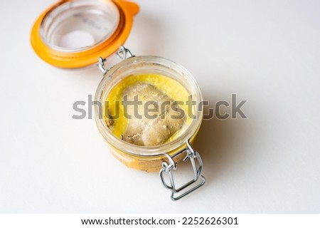Jar of goose liver foie gras on a white background.