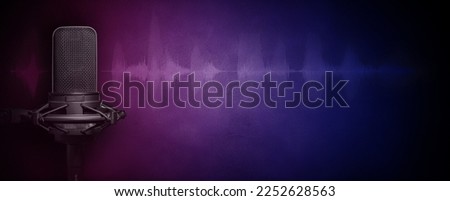Podcast microphone in the dark with pink and blue ligthing, audio wave signal and copy space. Recording studio banner design. Royalty-Free Stock Photo #2252628563
