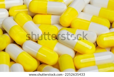 Pile of medical pills in yellow capsules. Royalty-Free Stock Photo #2252635433