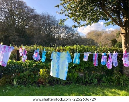 Tie dye washing line no branding pink  blue t-shirts, socks and knickers drying on a washing line on sunny day kids craft project Royalty-Free Stock Photo #2252636729