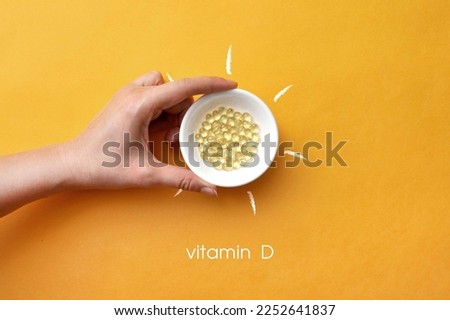 Tablets on a plate inside a picture of the sun and the inscription: vitamin D Royalty-Free Stock Photo #2252641837