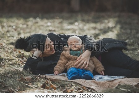 New born fall family photo shoot in forest with newborn sleeping on mom