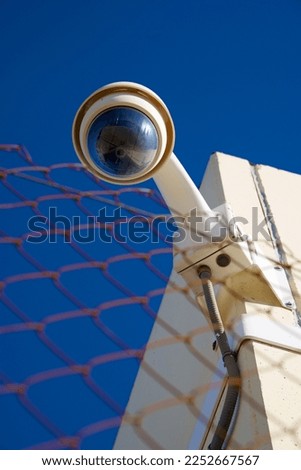 Closeup of a surveillance camera and clear sky. Royalty-Free Stock Photo #2252667567