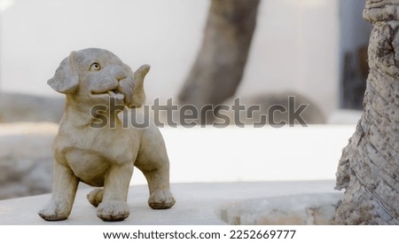Young little dog statue on natural light background.
