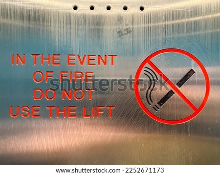 A no smoking sign and instructions to not use a lift in the event of fire.